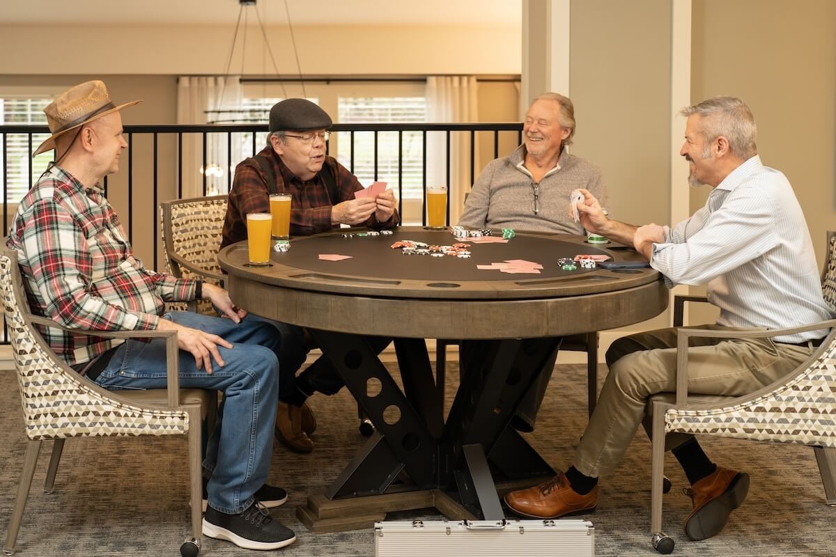 Four older men playing poker at table