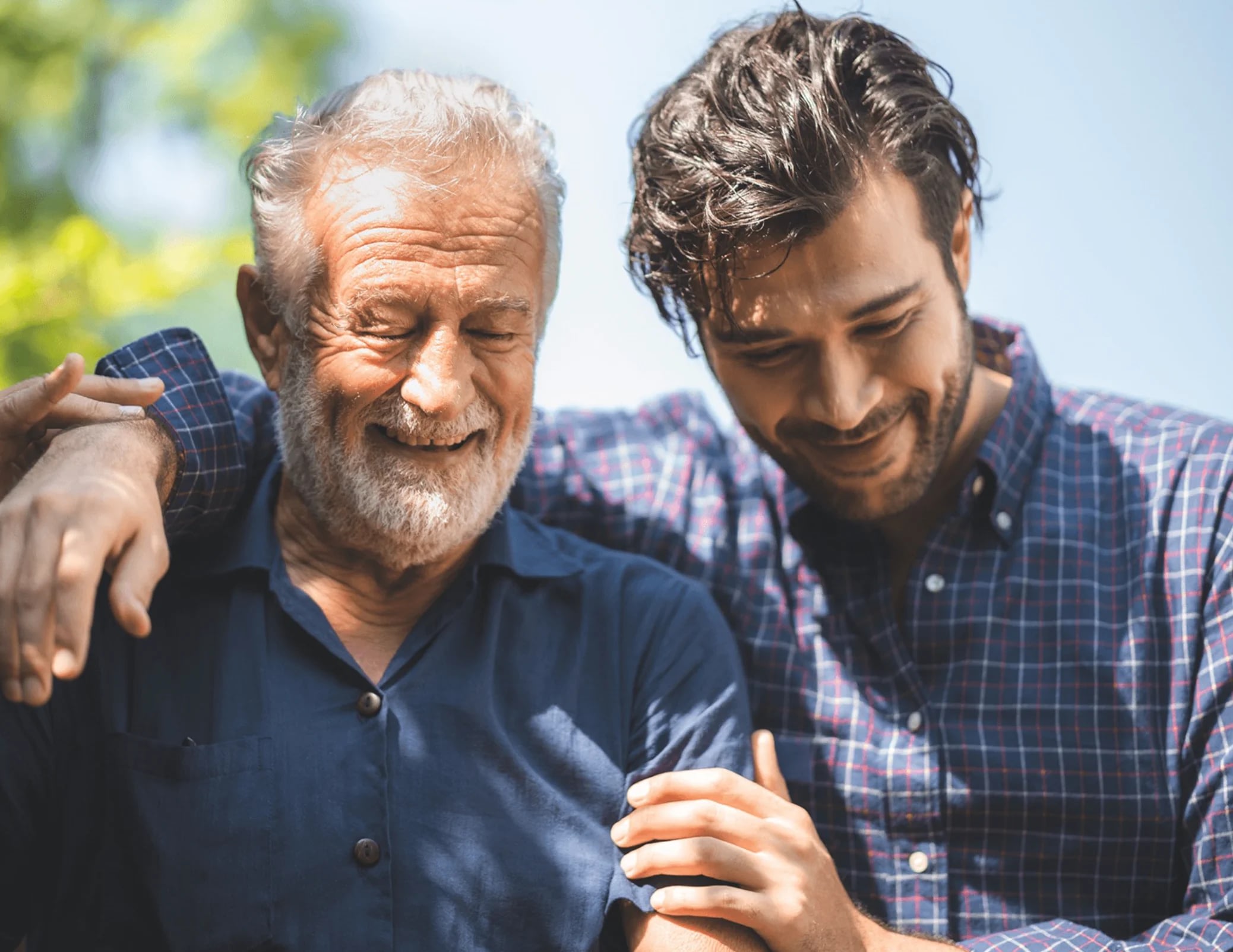 Older and younger man smiling outdoors together