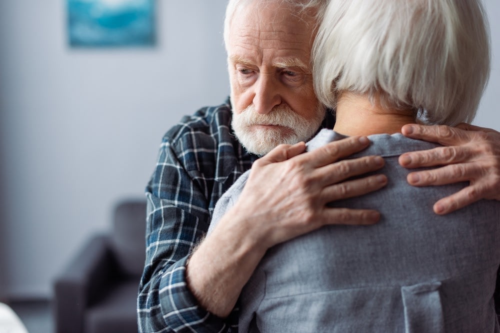 Elderly couple embracing in quiet home setting
