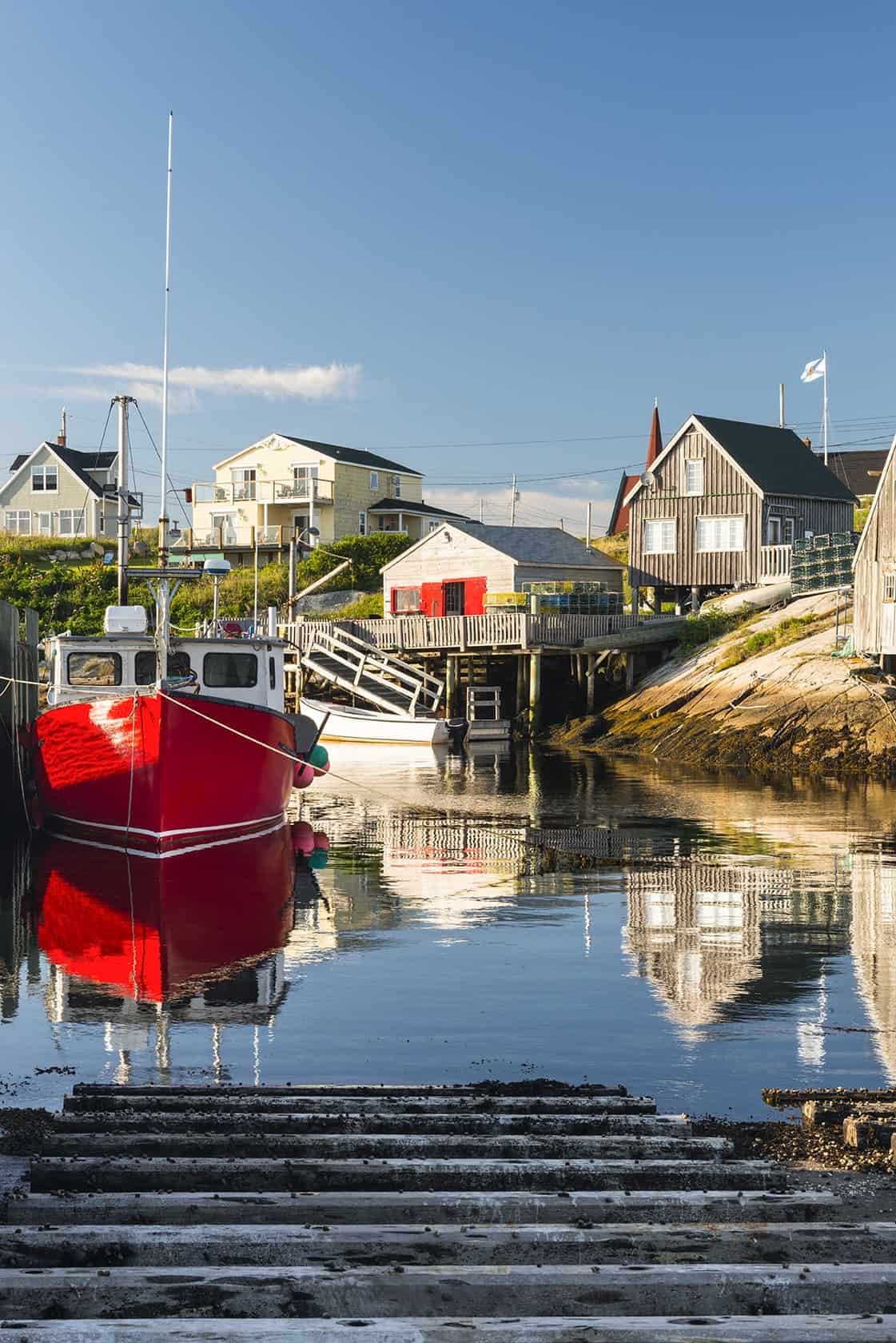 Red fishing boat in quiet coastal harbor