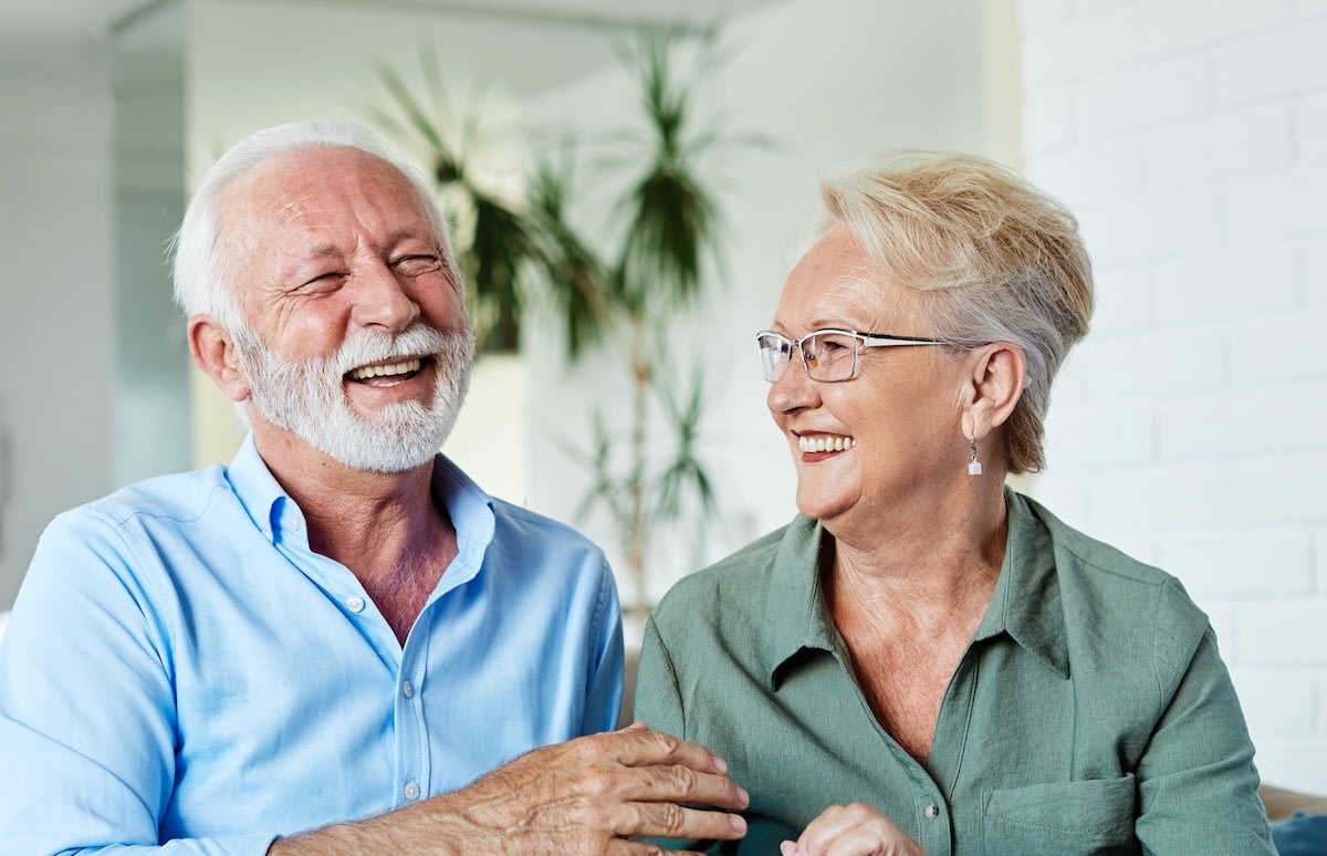 Smiling elderly couple laughing together indoors