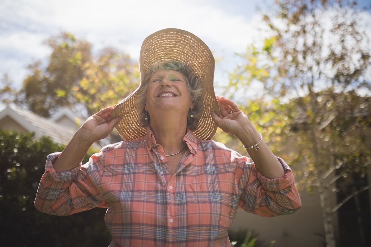 Smiling woman in straw hat outdoors