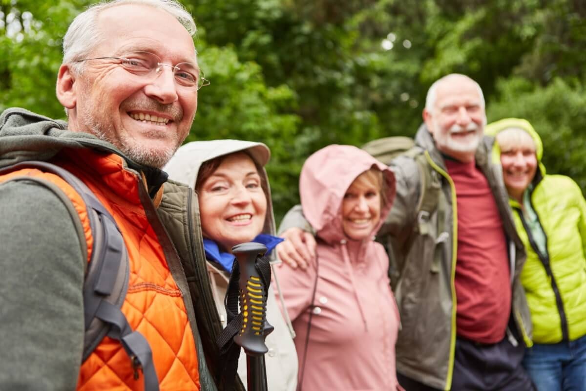 Group of senior hikers smiling on forest trail