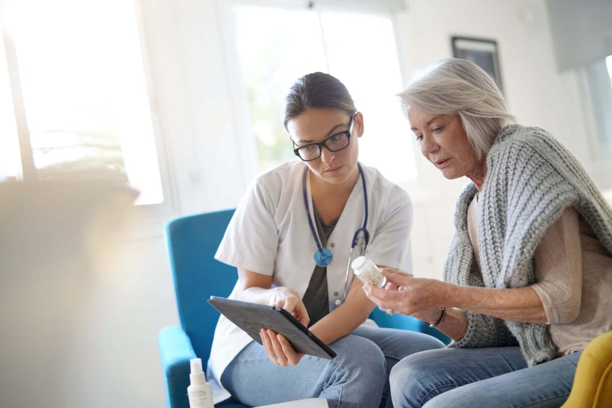 Nurse reviewing medication with elderly woman