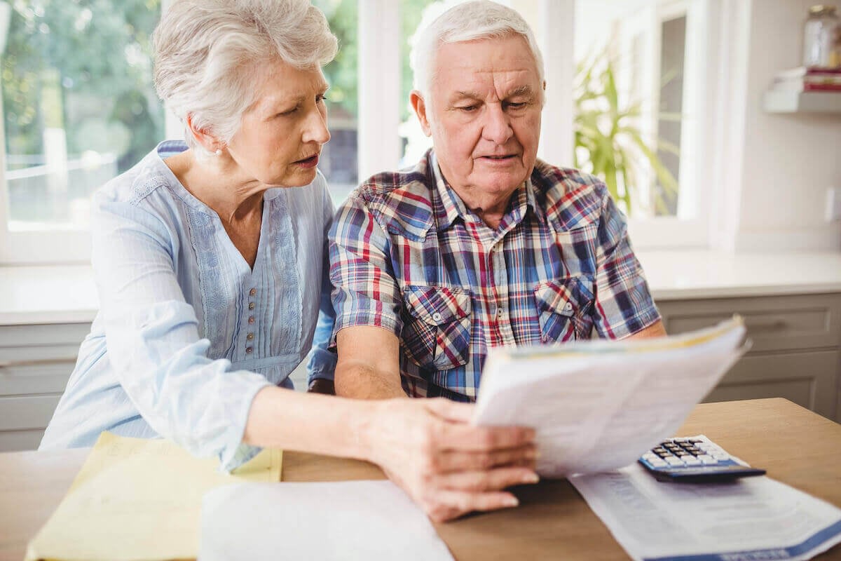 Senior couple reviewing bills at kitchen table