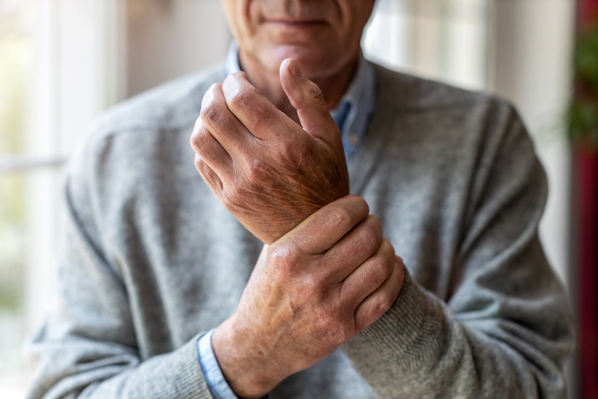 Older man holding wrist in pain