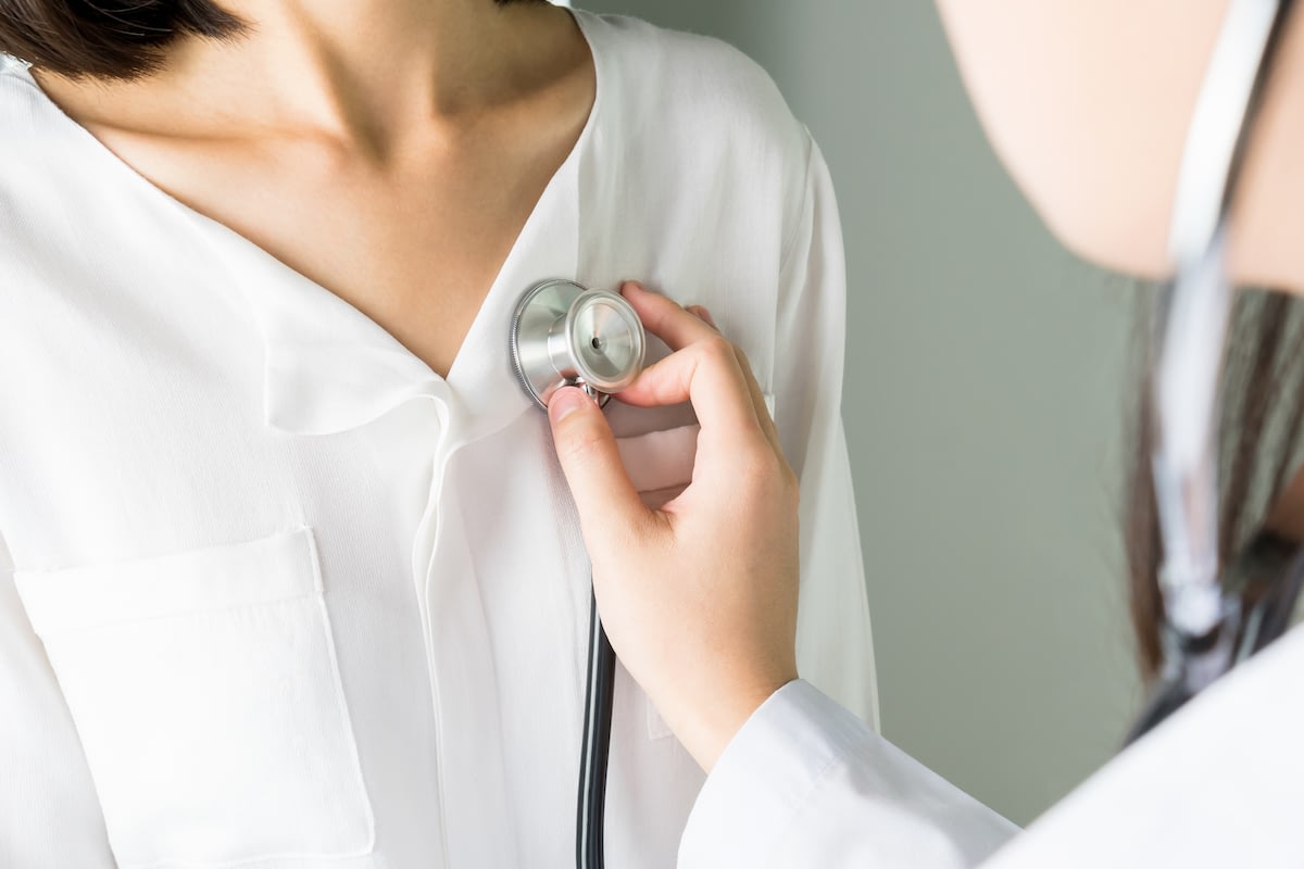 Doctor listening to patient's chest with stethoscope