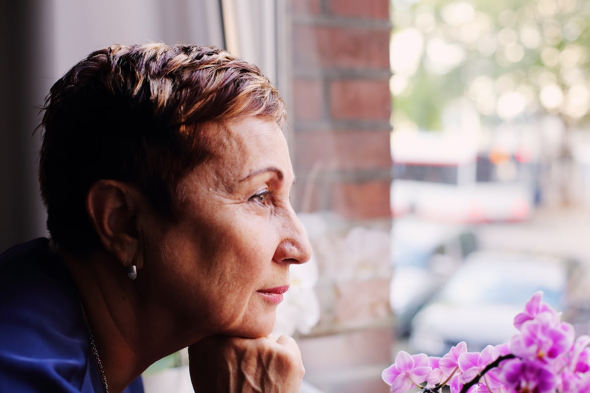 Older woman gazing thoughtfully out window
