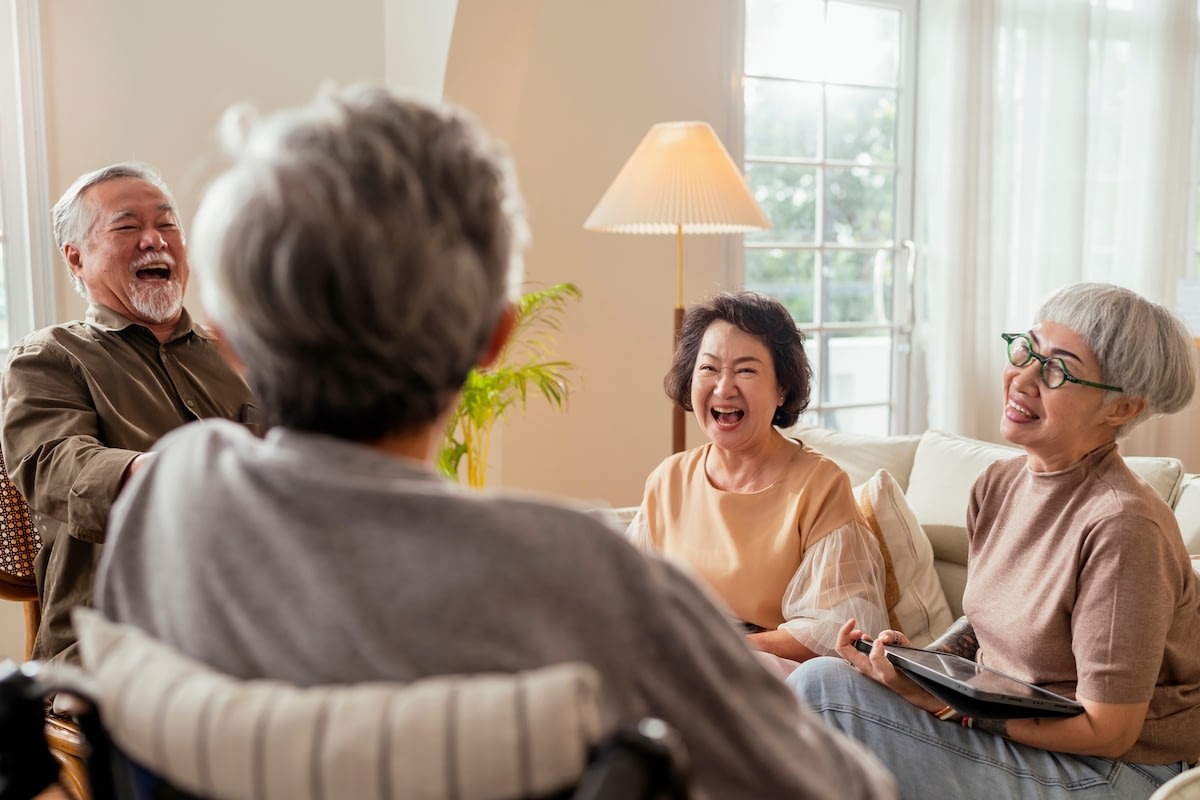 Seniors laughing together in a bright living room