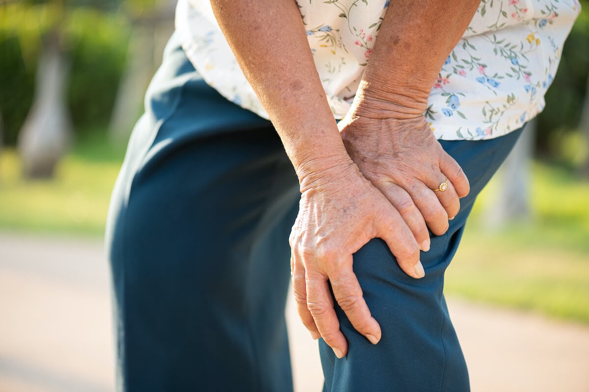 Older woman holding her knee in pain