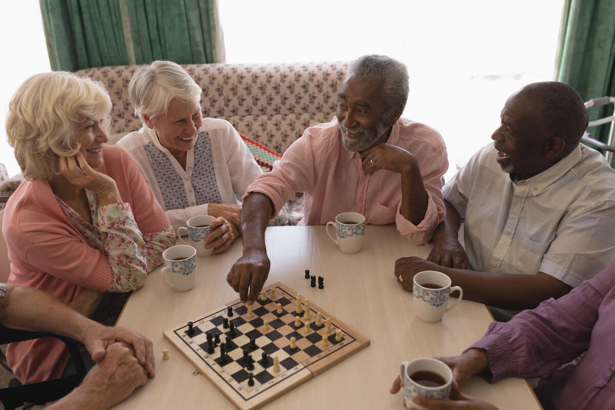 Seniors playing chess and drinking tea together