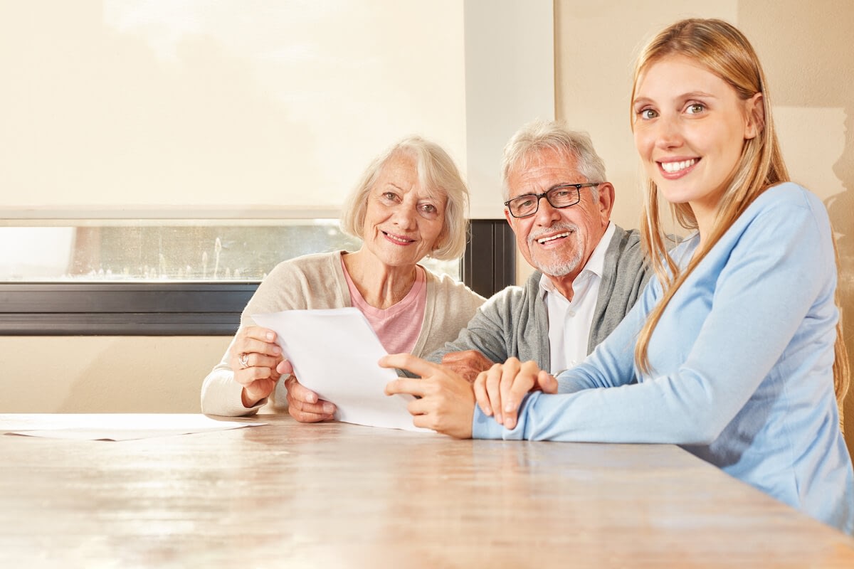 Senior couple reviewing document with younger advisor