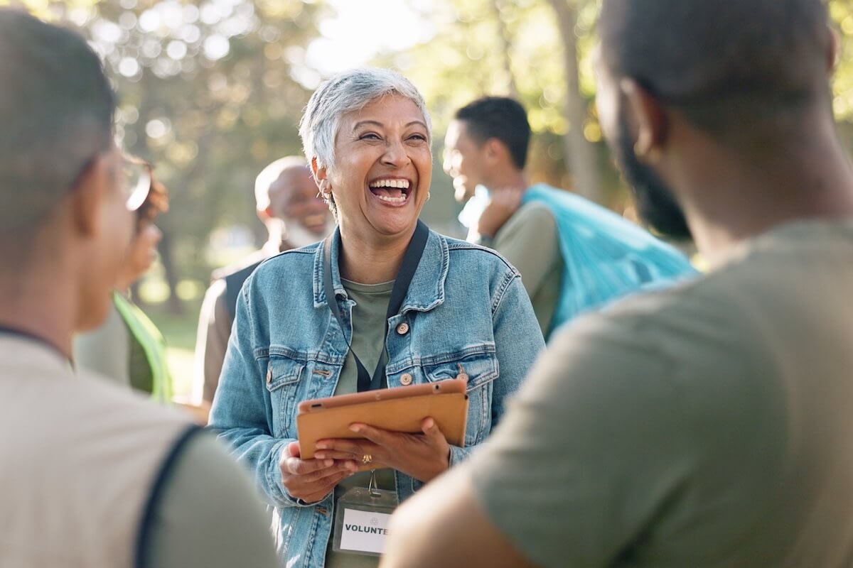 Smiling volunteer holding tablet at community event