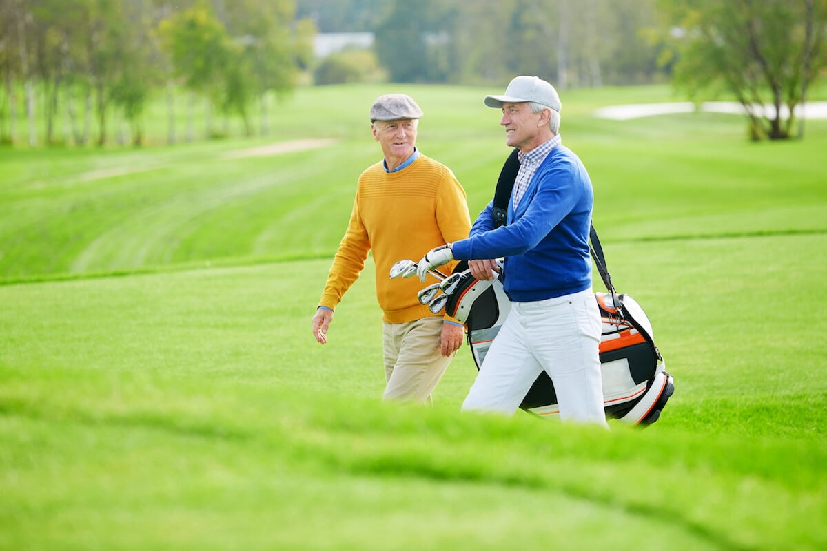 Two senior men walking on golf course