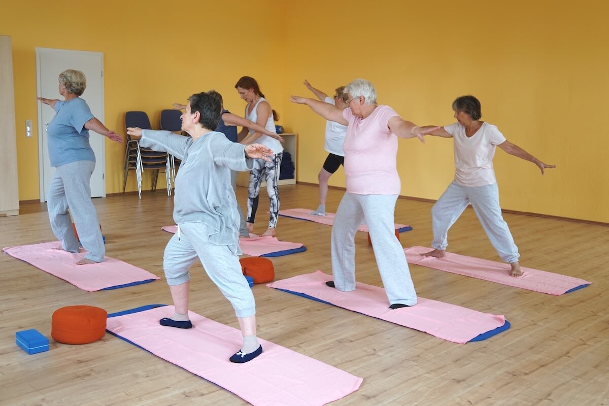 Senior women practicing yoga in studio class