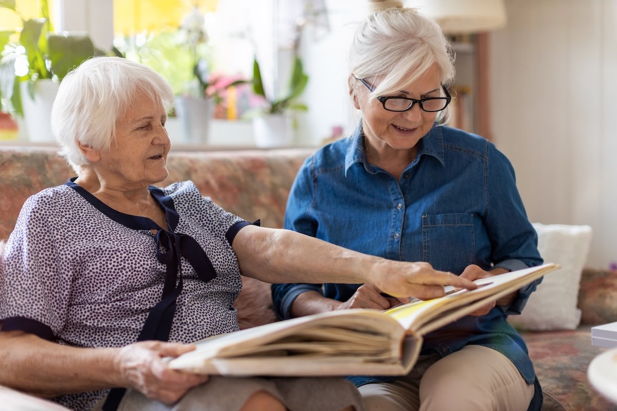 Two elderly women looking at photo album
