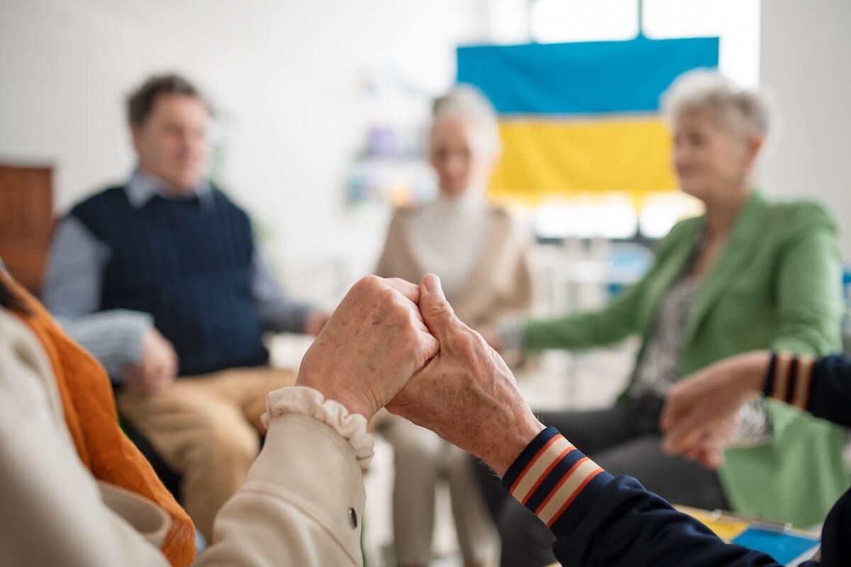 Seniors holding hands in support circle