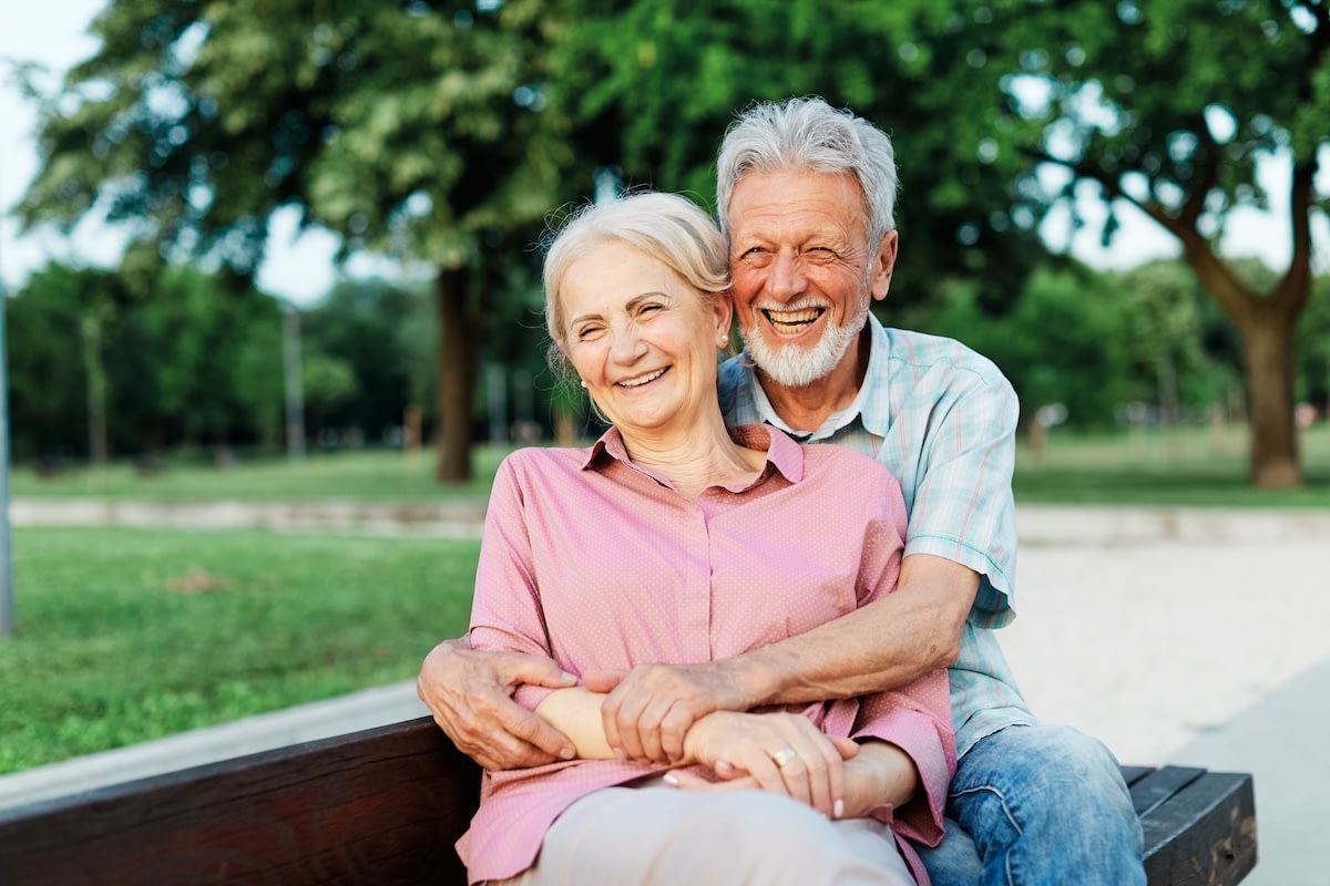 Senior couple smiling on park bench