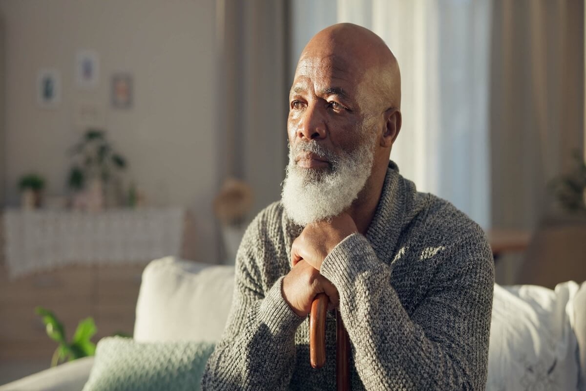 Elderly man with white beard holding cane