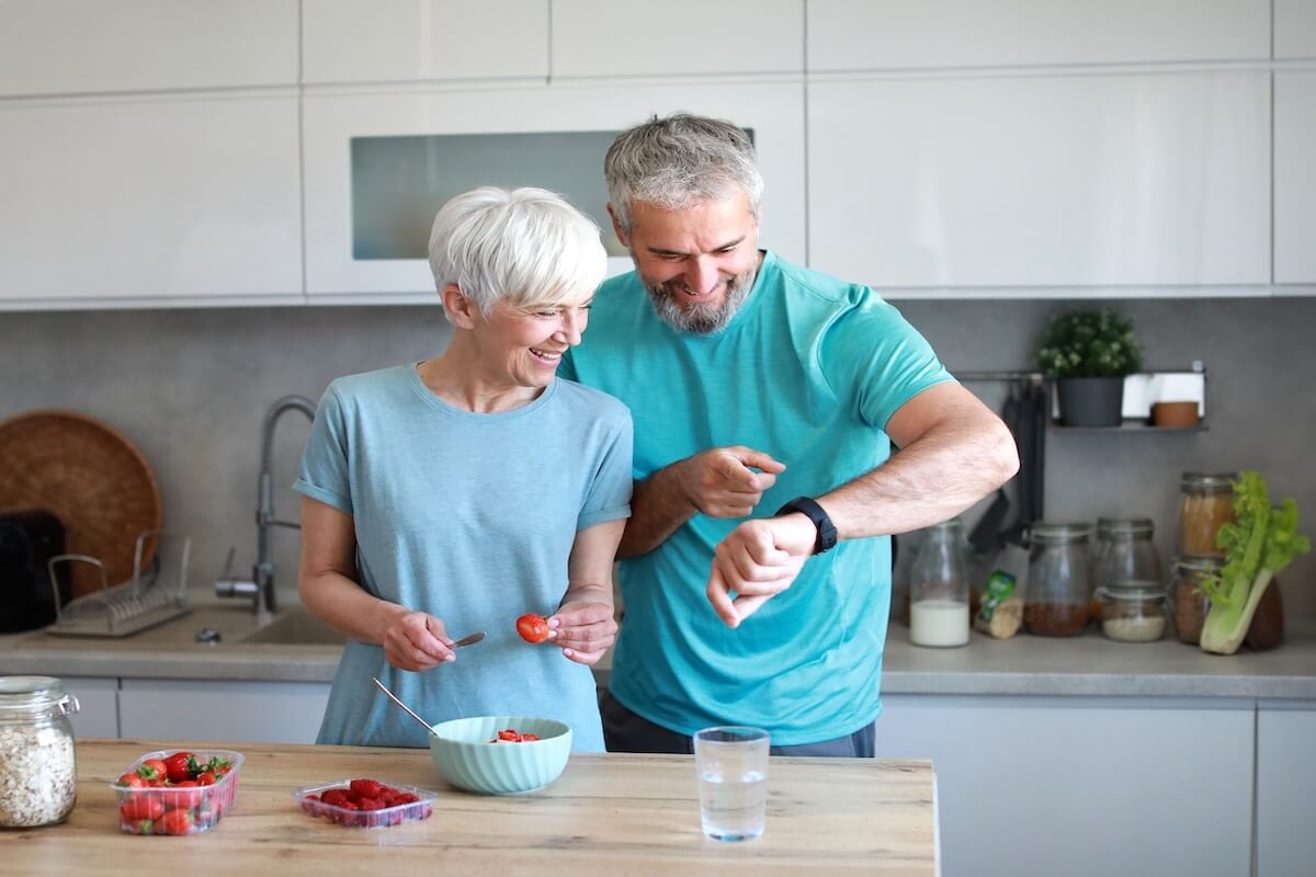 Older couple preparing fruit in modern kitchen