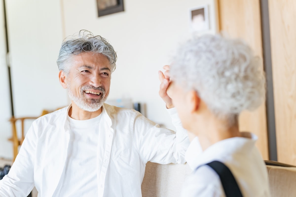 Smiling senior couple talking on living room couch