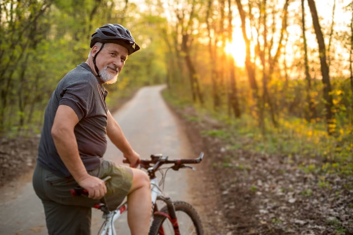 Man cycling on forest trail at sunset