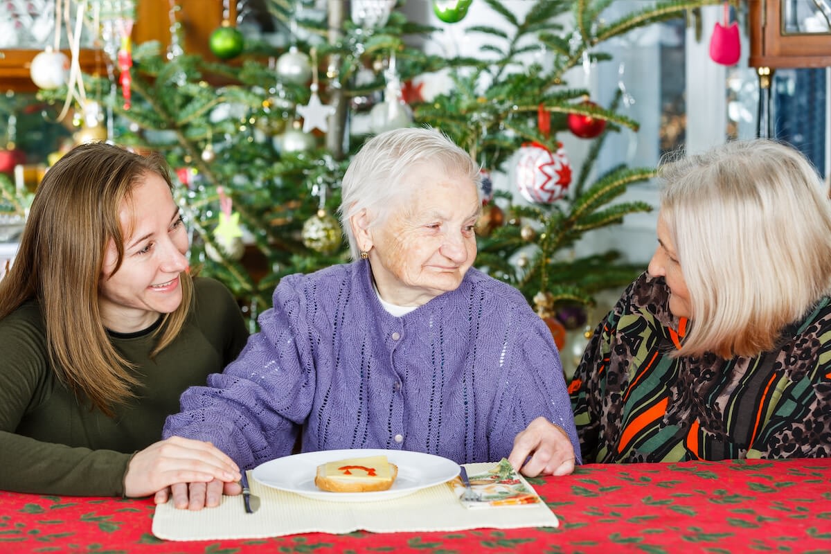 Three women celebrating Christmas at decorated table
