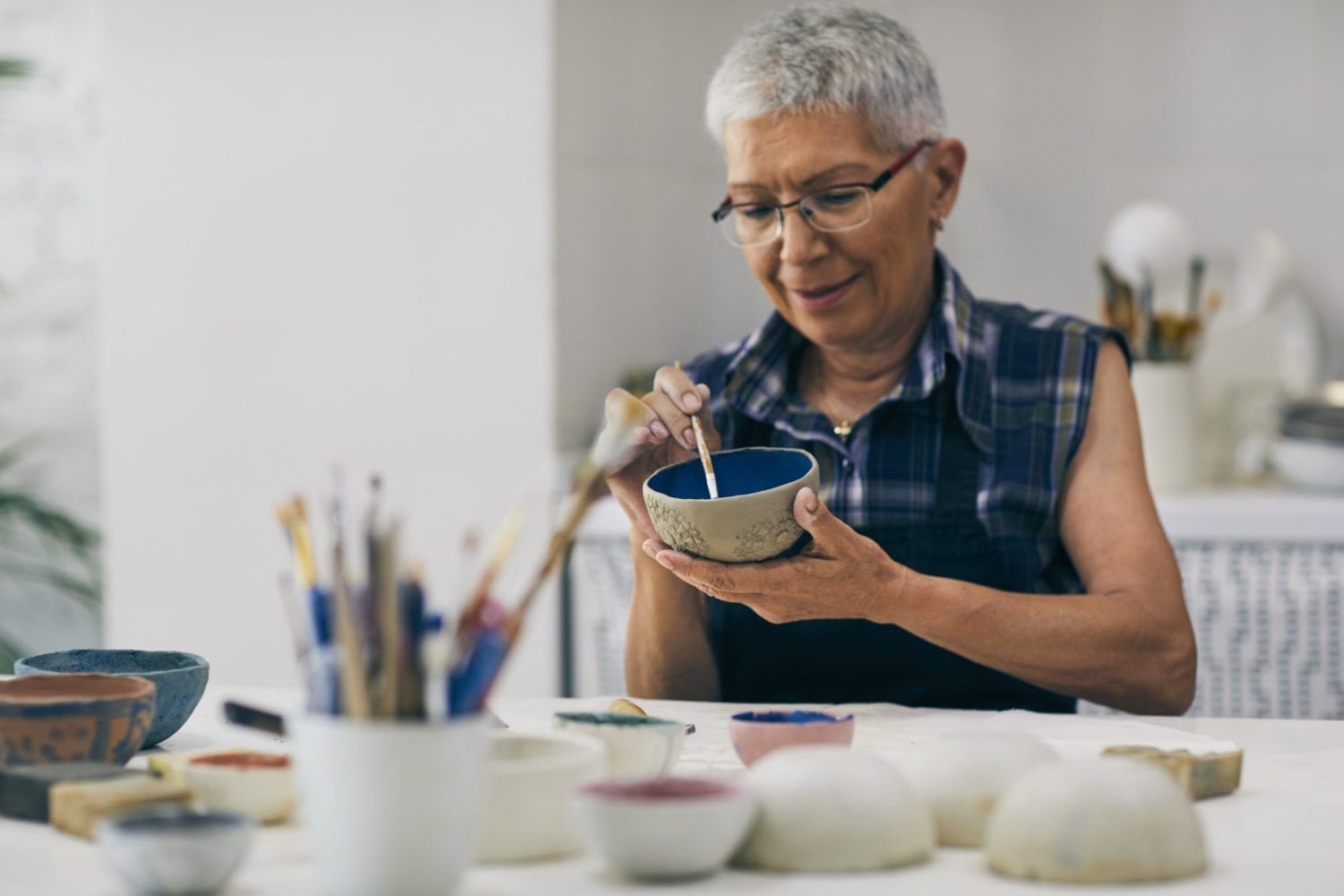 Woman painting a ceramic bowl at table
