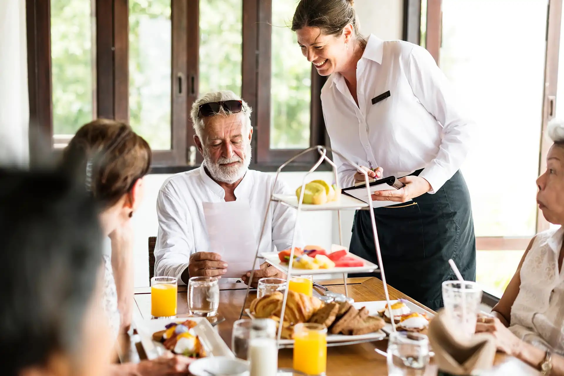 Waitress taking order from man at breakfast table
