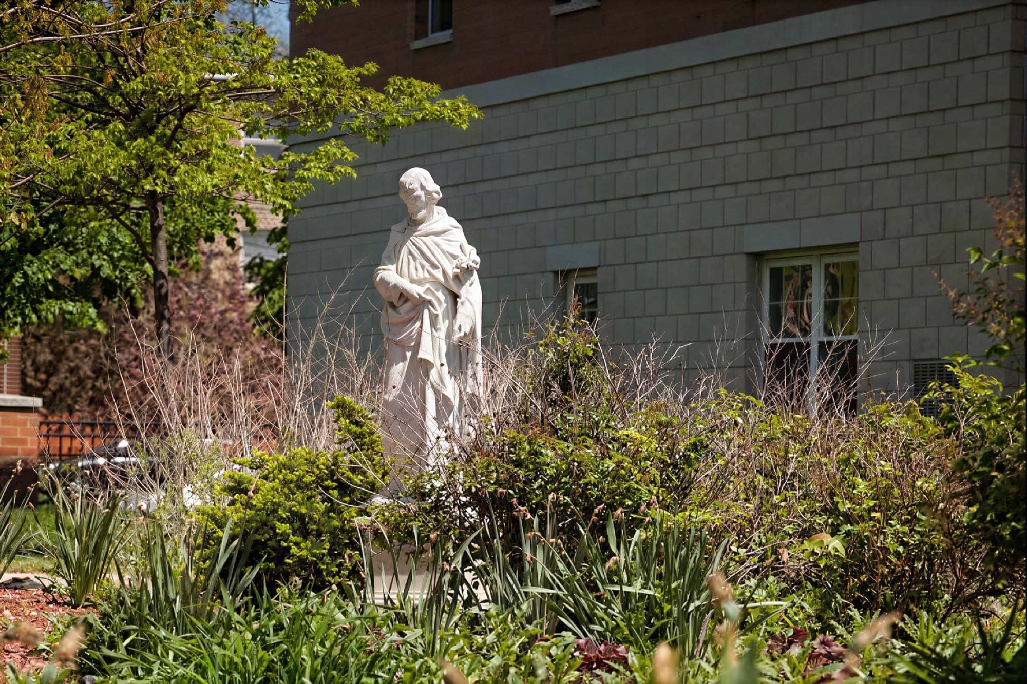 Stone statue in garden courtyard by building