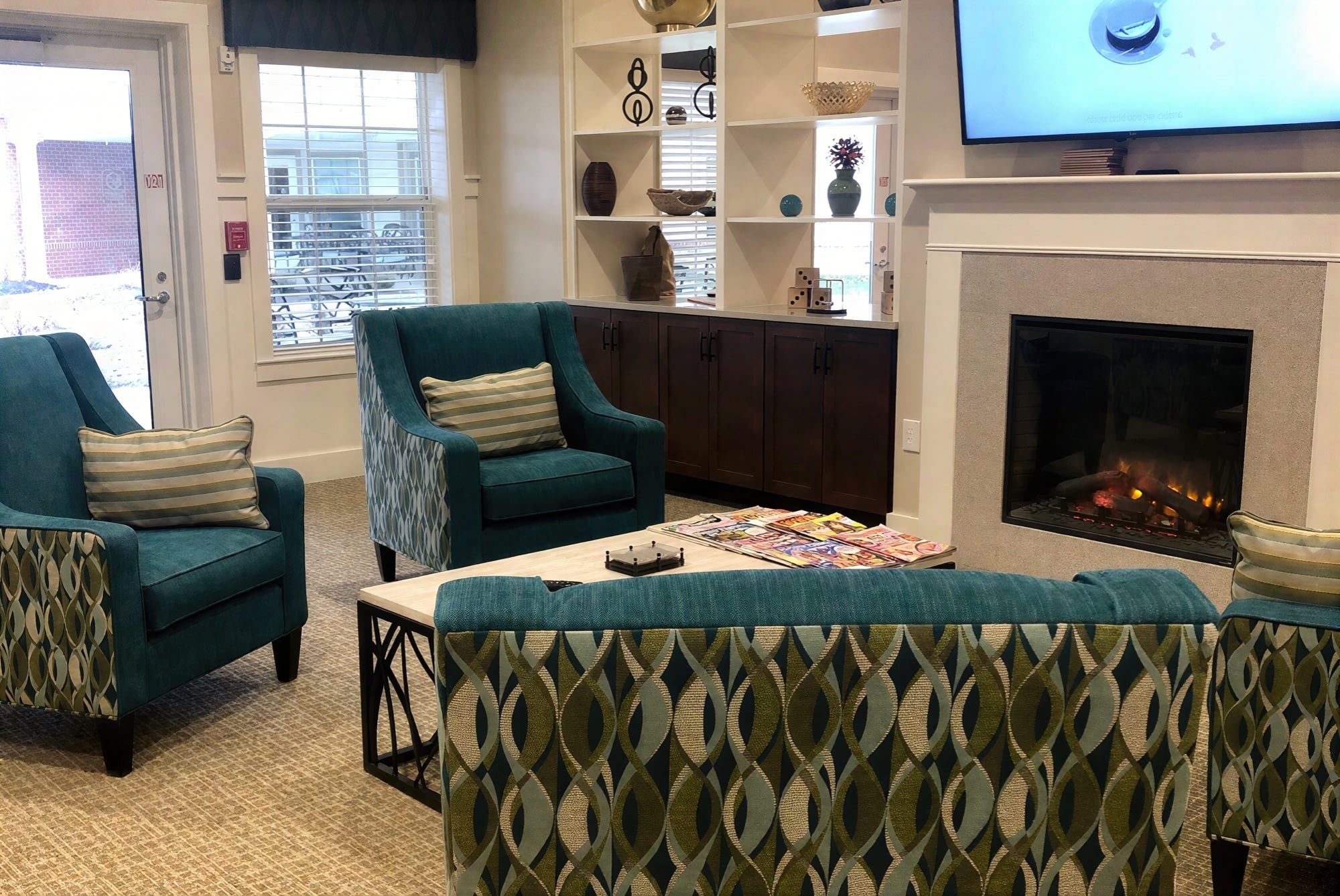 Cozy lounge with teal chairs and fireplace