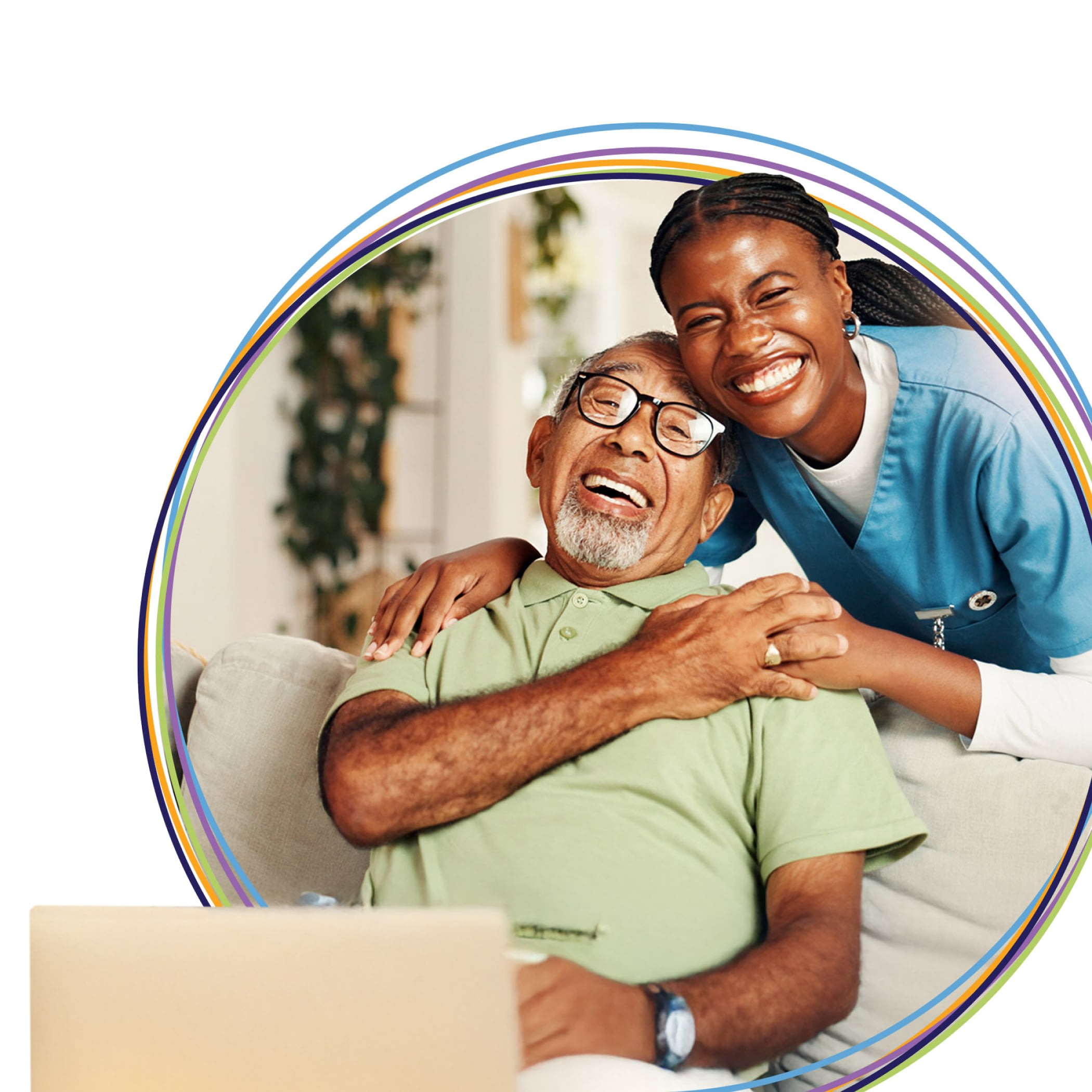 Caregiver hugging smiling elderly man on couch