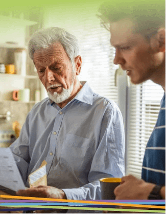 Older man and younger man reviewing documents indoors