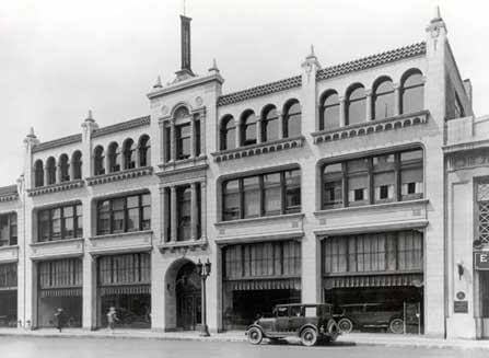 Historic multi-story commercial building with vintage cars
