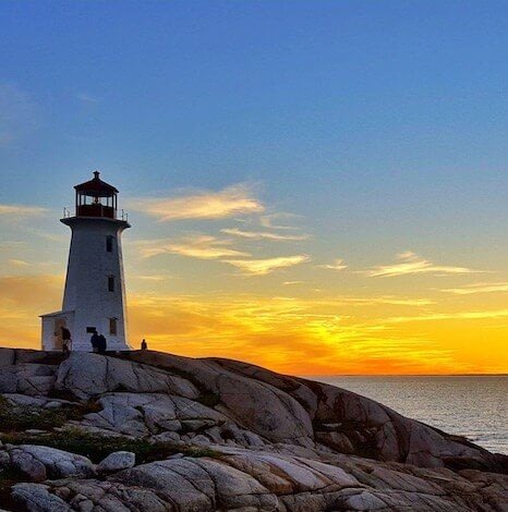 Lighthouse on rocky shore at sunset
