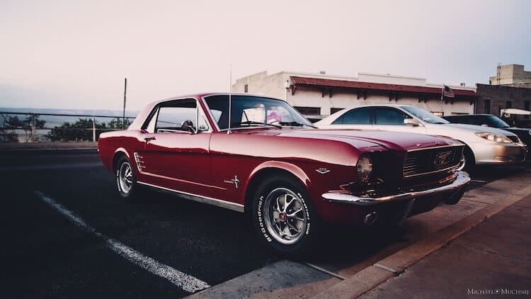 Classic red Ford Mustang parked at sunset