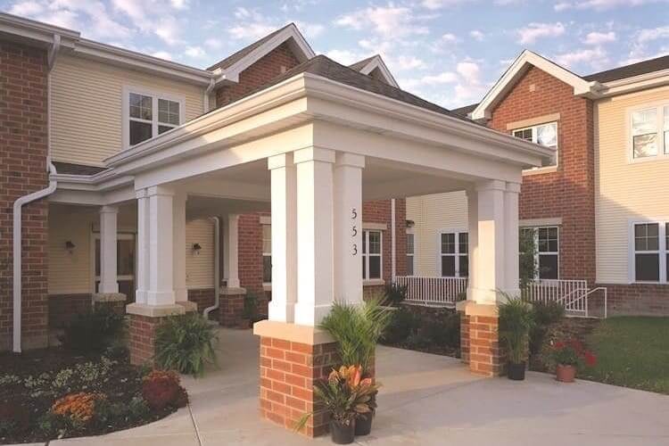 Brick apartment entrance with white columned portico