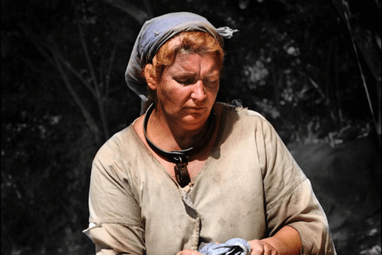 Woman in headscarf working outdoors in rustic setting