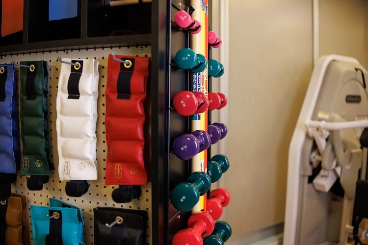 Colorful dumbbells and weighted bags in gym