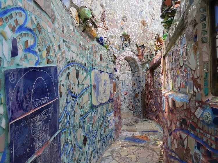 Colorful mosaic-covered alley with tiled archway