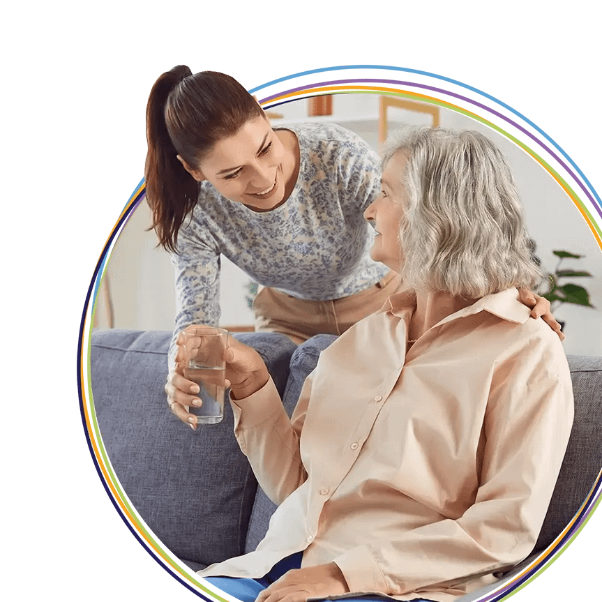 Caregiver giving elderly woman a glass of water