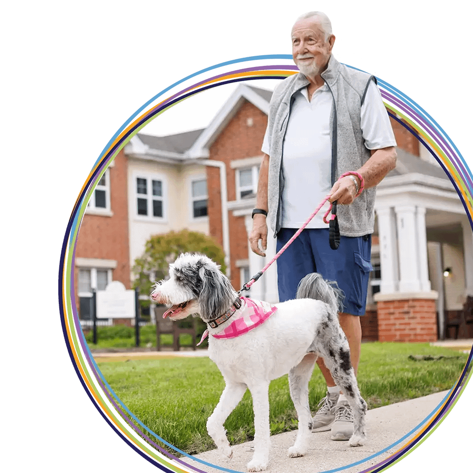Elderly man walking small dog outdoors