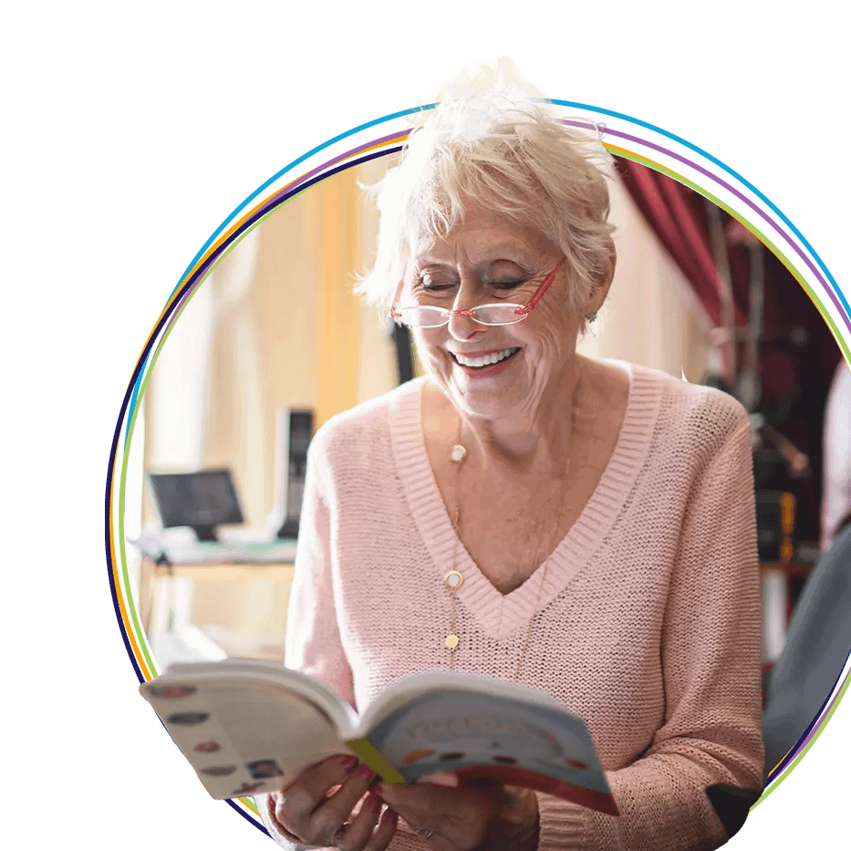 Smiling elderly woman reading a book indoors