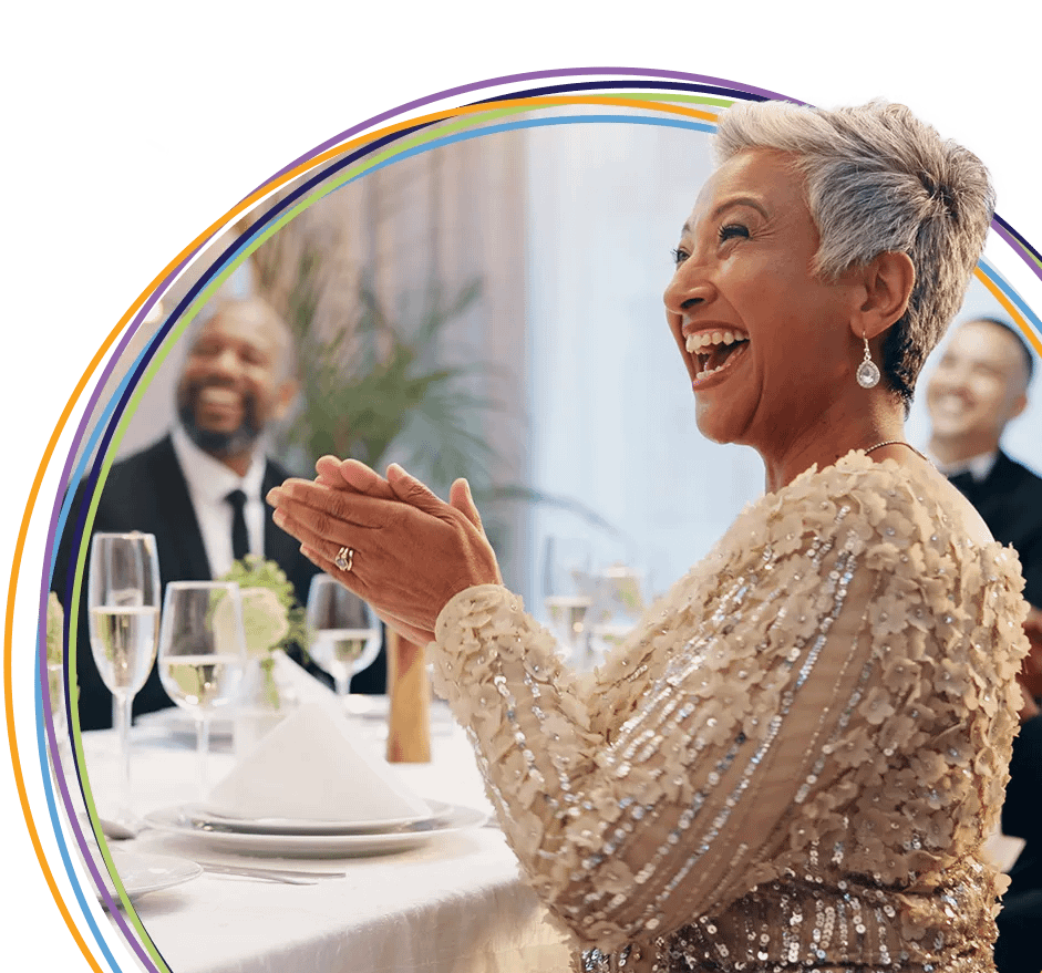 Elegant woman laughing and clapping at formal dinner