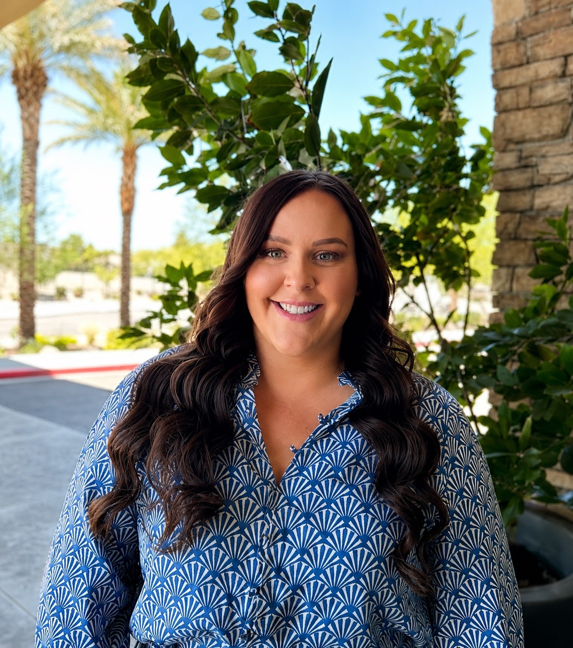 Smiling woman in blue patterned blouse outdoors