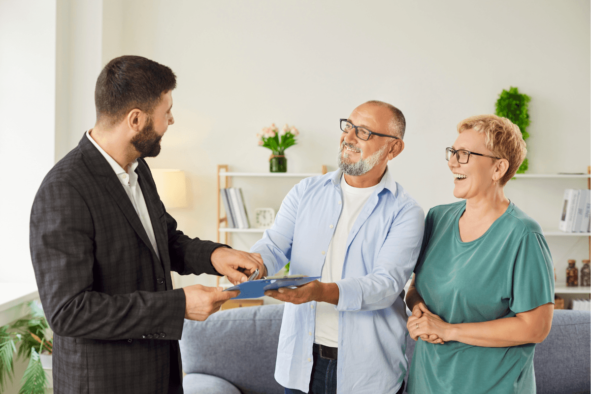 Real estate agent handing keys to happy couple