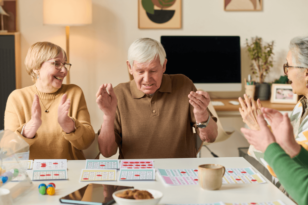 Seniors celebrating bingo win at table