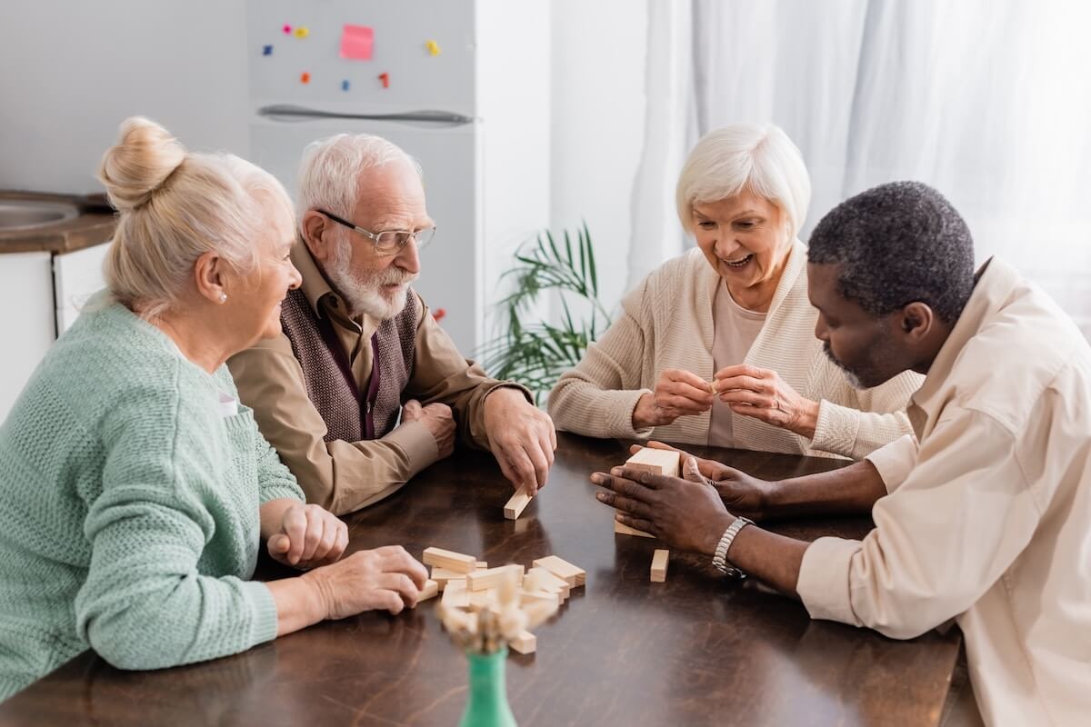 Four seniors playing wooden block game together