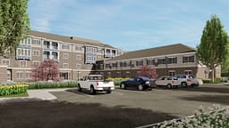 Modern apartment complex with parking lot and landscaping