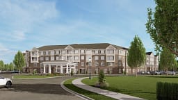 Four-story apartment building with landscaped entrance